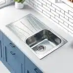Reginox Diplomat 10 Lux single bowl stainless steel kitchen sink installed in a modern kitchen.