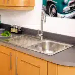 Reginox Centurio 10 single bowl stainless steel kitchen sink installed in a contemporary kitchen.